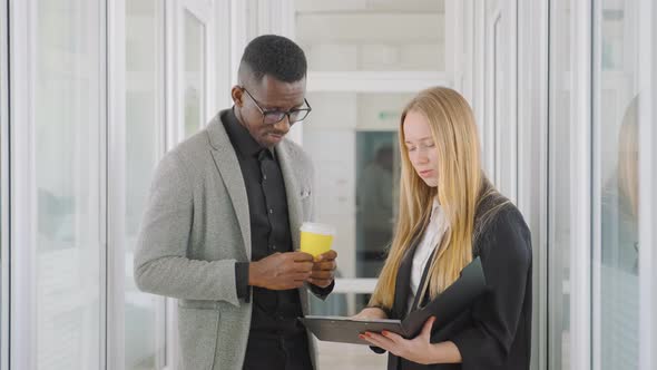 Multinational Business Team of Two People Man and Woman Talking in Office Hall