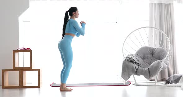 Young fitness woman doing squat exercises with lunges from leg to leg.