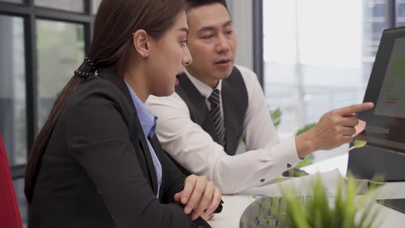 Asian young business man and woman people use computer and having a discussion meeting in office. alt