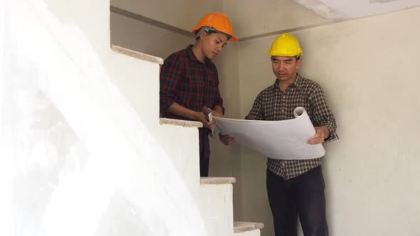 Architect discuss with engineer about project in construction site.