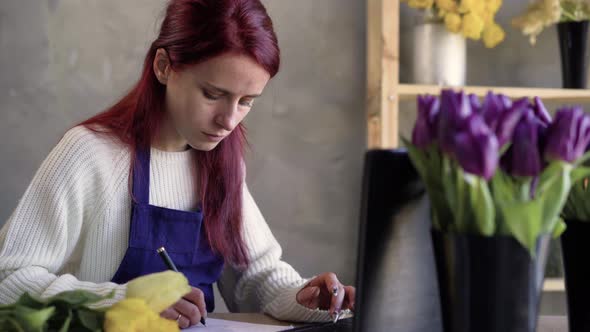 Portrait of a Young and Attractive Caucasian Businesswoman Florist and Saleswoman Using a Laptop to alt