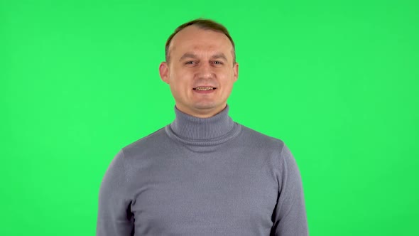 Portrait of Male Waving Hand and Showing Gesture Come Here. Green Screen alt