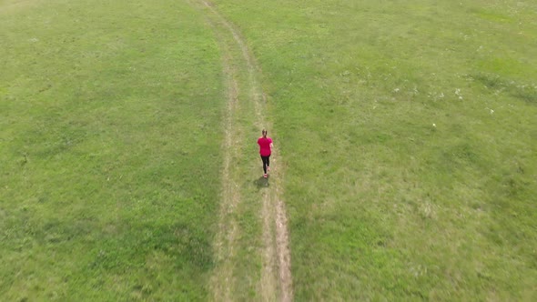 Sporty teenager running on meadow