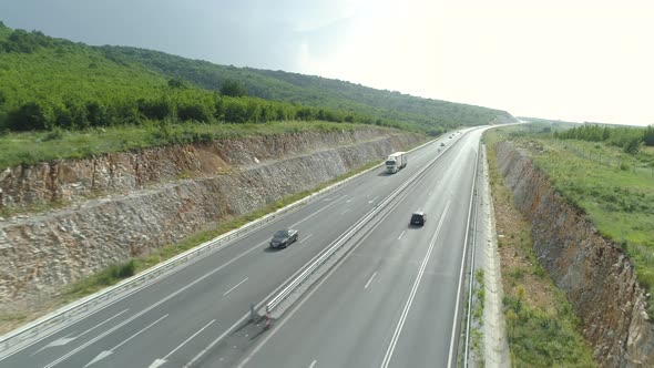 Aerial View of Highway Between Green Hills with Busy Summer Traffic in Hot Day alt