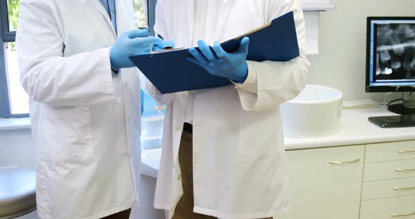 Attentive dentists discussing reports alt