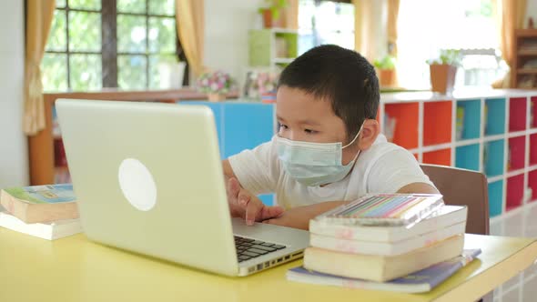 Back to School, Online learning, Asian little child with face mask using laptop