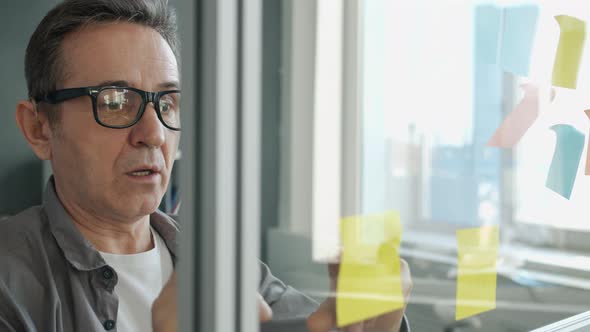 Creative Businessman Working with Sticky Notes Writing Down Ideas in Modern Office alt