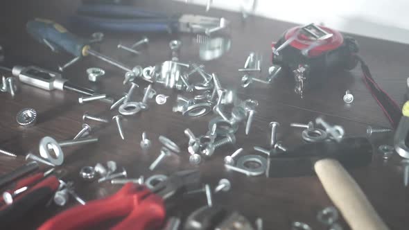 View Bolts Nuts Selftapping Screws Fall on the Table Hand Tools in the Workshop alt