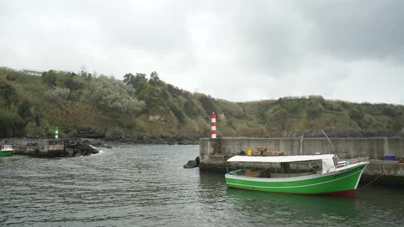 green boat in the water - porto formoso harbor, azores alt