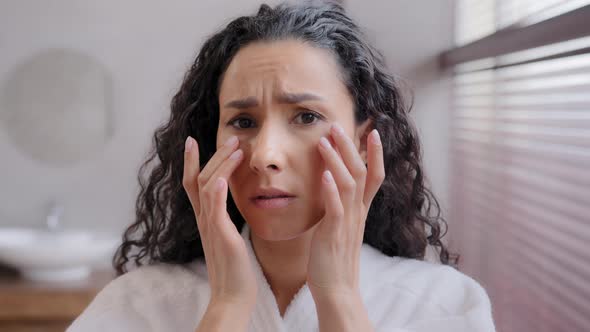 Headshot Worried Frustrated Young Woman Looking in Mirror in Bathroom Worrying About First Wrinkles alt