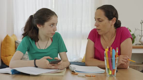 Mother helping her teenage daughter prepare homework alt