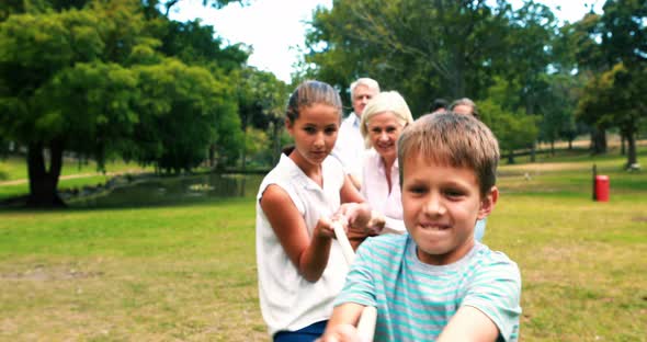 Multi-generation family pulling a rope in tug of war alt