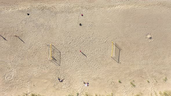 AERIAL: Symmetrical Descend Shot of Football Court on a Sandy Beach on Sunny Day