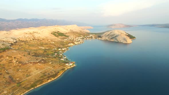 Flying above barren coast of Pag island a sunset, Croatia alt