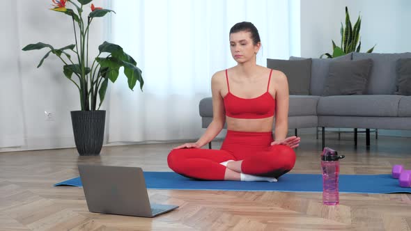 Sportive Fit Woman Sitting on Yoga Mat Dancing Makes Wave with Hands at Home alt