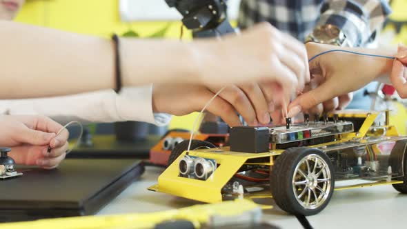 Unrecognizable Students Assembling Car in Robotics Class