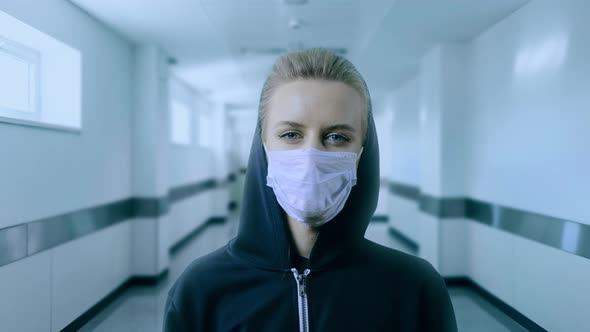 Woman Wearing Face Mask Because of Air Pollution or Virus Epidemic in the Hospital Corridor alt