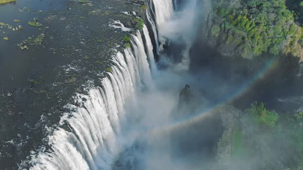 Aerial drone footage of rainbow in Victoria Falls between Zambia and Zimbabwe in Southern Africa.