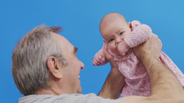 Funny Game and Laugh of Caucasian Old Man and Baby Girl in Domestic Comfort. Wrinkled Skin of alt