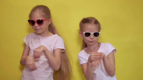 Side View of Little Sisters in Trendy Sunglasses and White t Shirts Keeping Hands Like Rabbit Paws