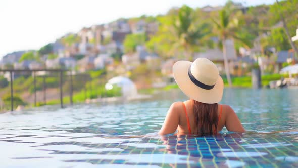 Young asian woman enjoy around outdoor swimming pool for leisure alt