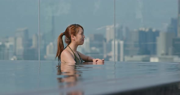 Woman at Infinity Swimming Pool with City View