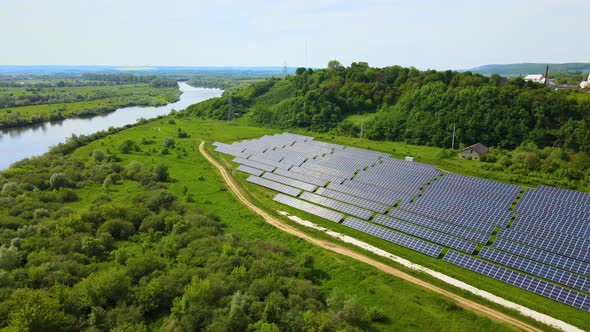 Aerial view of big sustainable electric power plant with many rows of solar photovoltaic panels alt