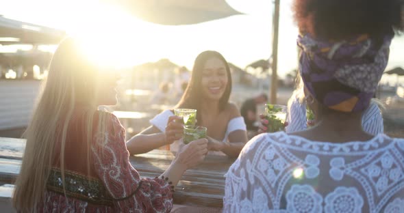 Happy multiracial girls having fun drinking mojitos at beach party outdoor alt