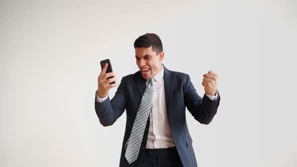 Happy Male Office Worker in Formal Clothes Uses Mobile Phone Rejoices in Victory alt