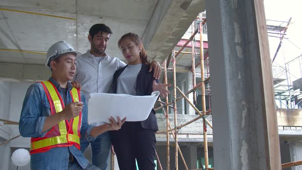 Young Asian engineers and caucasian engineer colleagues at site inspector and discuss together