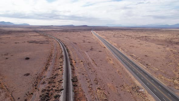 Drone shot of a modern highway and old railroad tracks leading far off alt