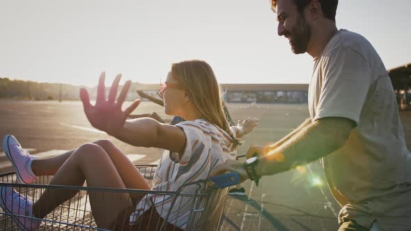 Friends Racing on Shopping Carts with Girlfriends at Deserted Car Parking alt