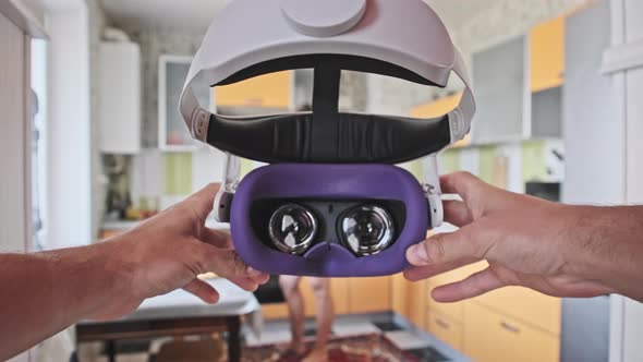 Man Taking On VR Helmet at Home Kitchen Point of View alt