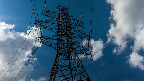 electrical network, pylon with high-voltage wires on the background of clouds, time-lapse green ener alt
