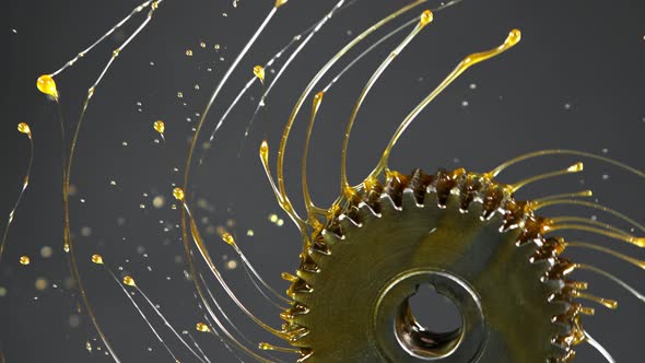 Super Slow Motion Shot of Rotating and Splashing Metal Cogwheel on Dark Background at 1000 Fps alt