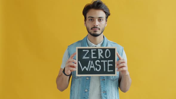 Slow Motion Portrait of Serious Middle Eastern Guy Holding Zero Waste Banner alt