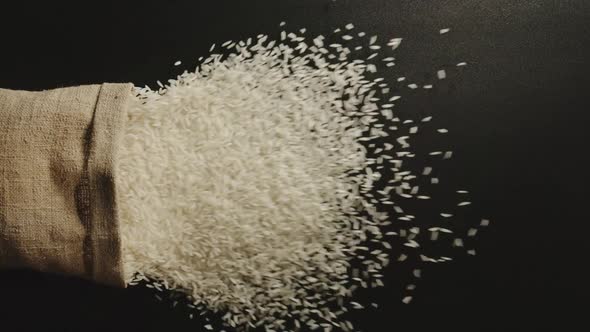 Rice Pours Out Of Falling Sack On Black Table