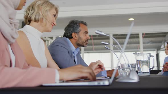 A panel of business delegates talking at a conference alt