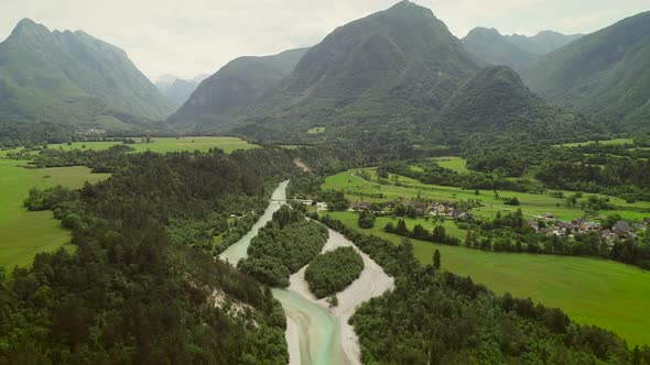 Aerial view of a small village with typical houses next to Soca river, Slovenia. alt