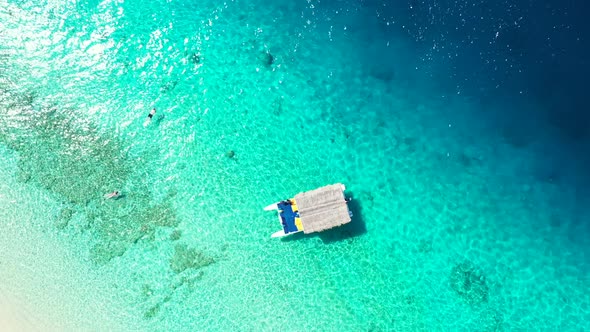 Touring boat with straw roof floats over crystal emerald water on seashore of tropical island, touri alt
