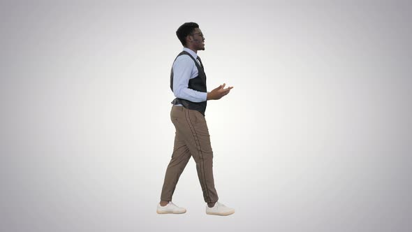 Young African American Businessman Gesturing and Talking To Camera While Walking on Gradient alt