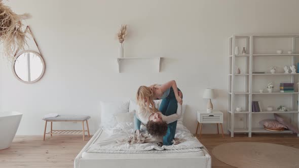 Young Teens Couple Dancing Jumping on Bed Mattress Active Carefree Hipster and Young Blonde Having alt