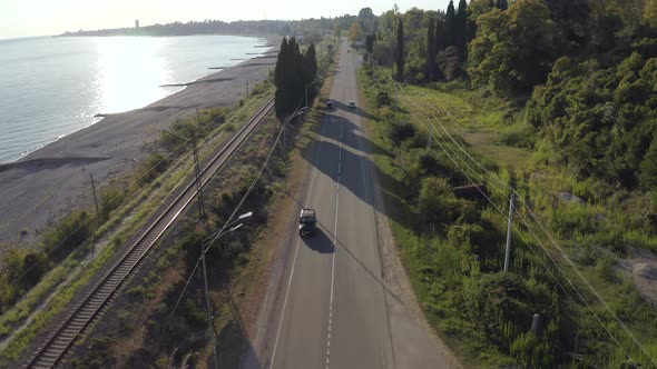 Suv Black Car Drive Along Grey Asphalt Coastal Highway Between Forest alt