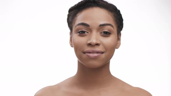 Young African American Woman Stepping Forward To Camera Focus and Smiling White Background alt