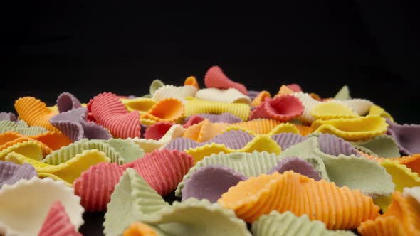 Creative Multicolored Pasta Farfalle on a Black Background in Perspective Background