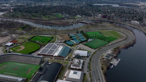 Aerial Panoramic View of Multilane Road Winding on Charles River Waterfront Around Sports Area alt