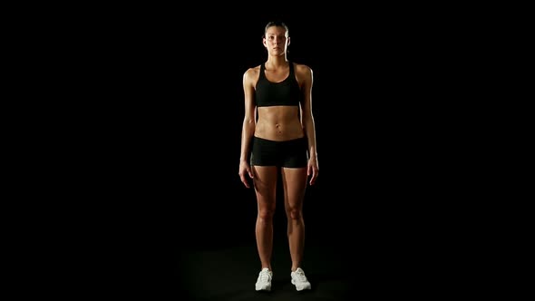 Young Athletic Woman Wearing Sporstwear is Relaxing Isolated on Black alt