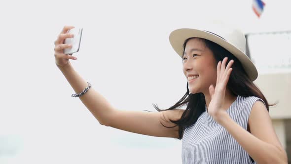 Beautiful Asian woman taking selfies on a smartphone.