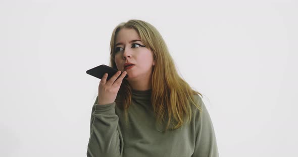 Thoughtful Lady Talks Using Speaker Mode on Smartphone alt