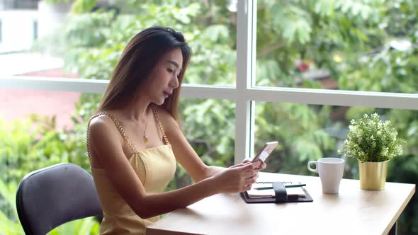 Young pretty woman using smartphone at coffee shop